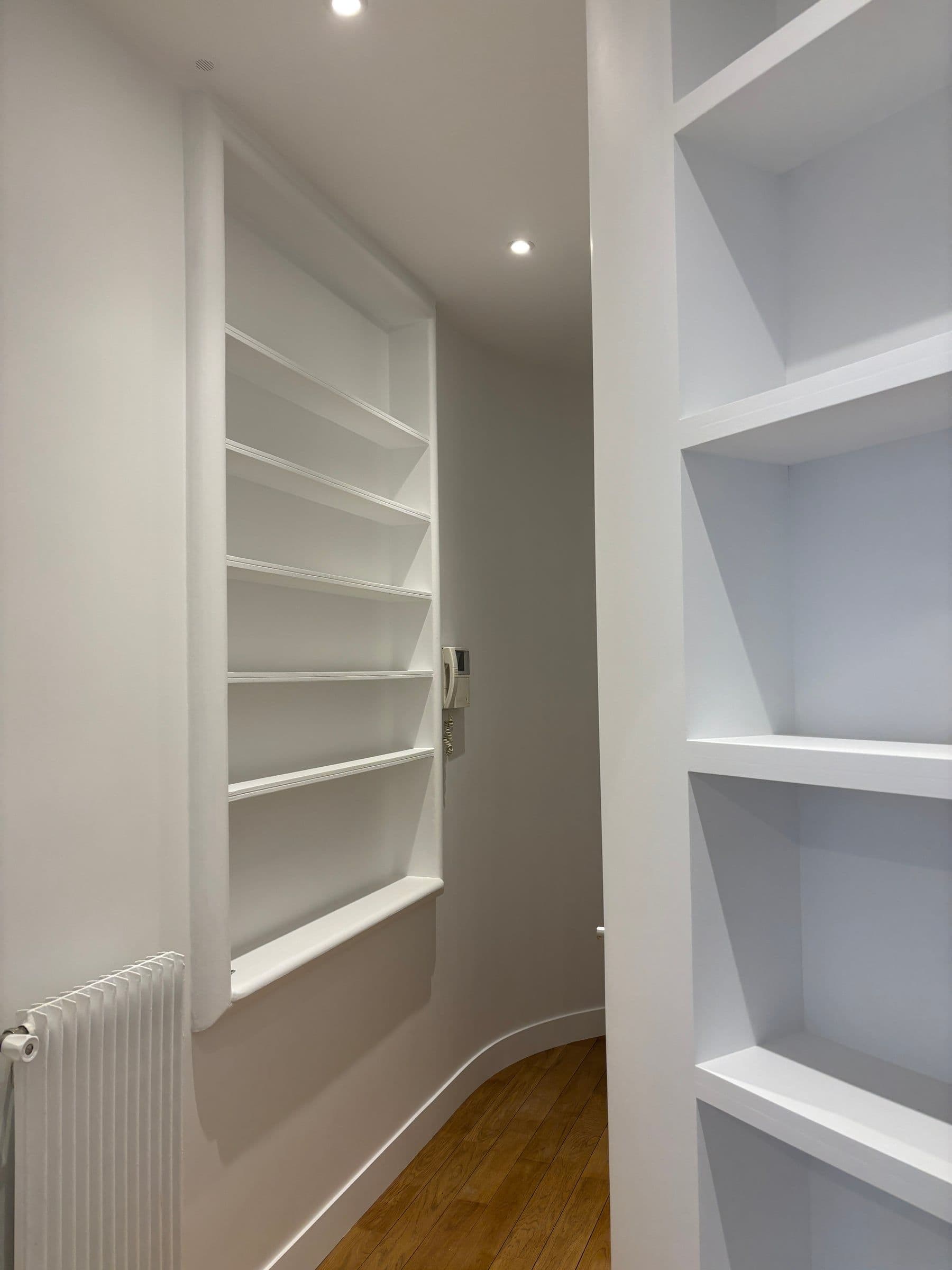 Après travaux : plafond à caissons blancs et corniches restaurées, spots encastrés et amorce de parquet en chêne après rénovation d'appartement.
