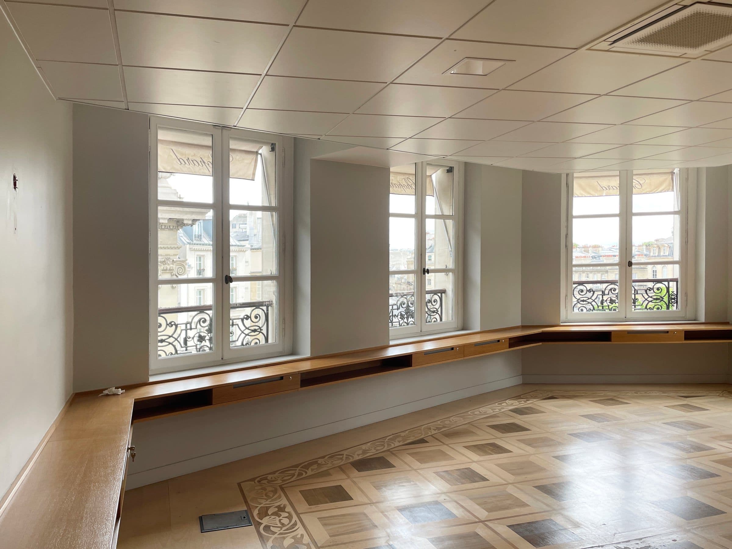 Avant travaux : plateau de bureaux Chopard avec faux plafond à dalles, allège en bois sous bow-window et sol en damier vétuste