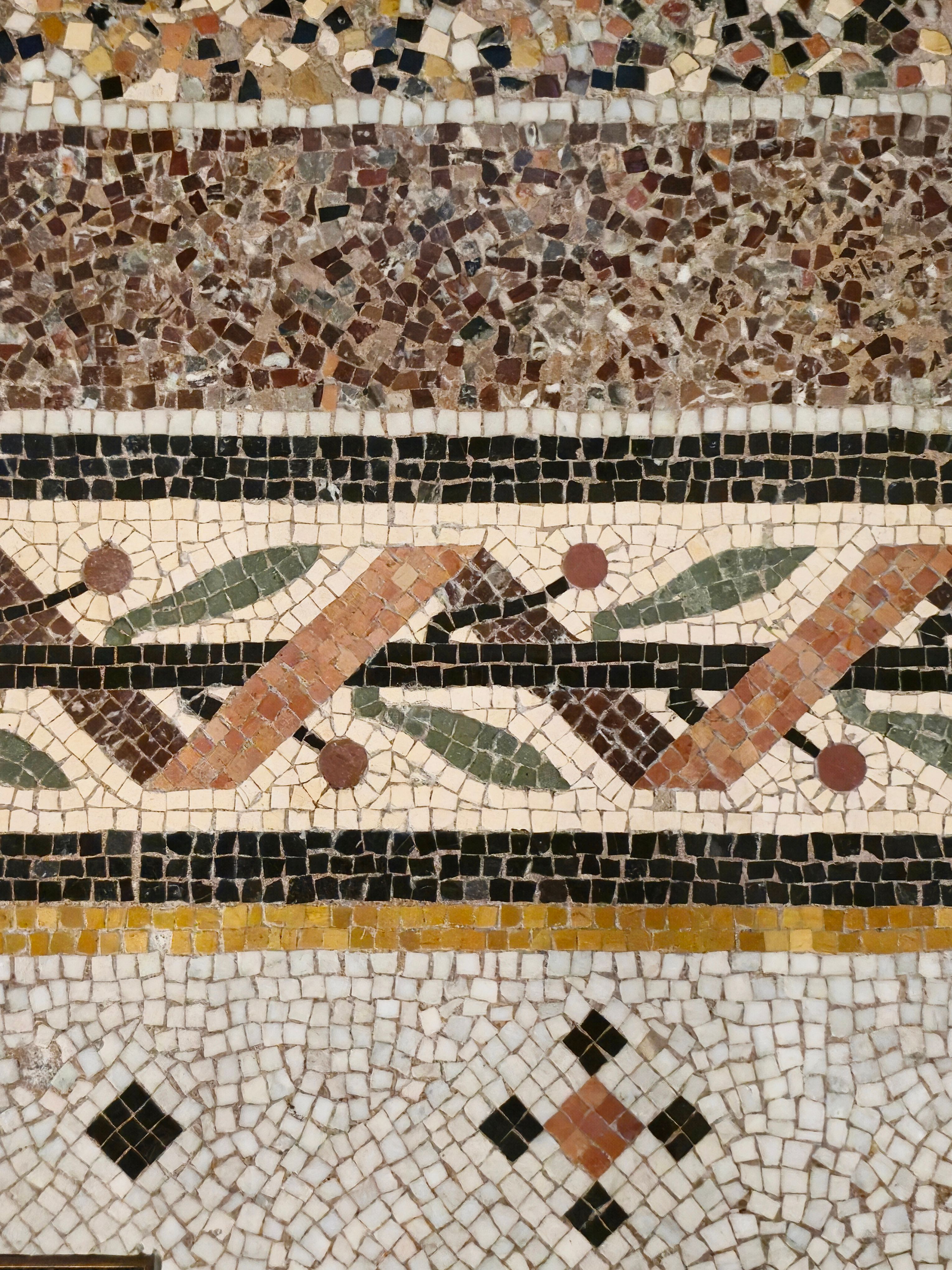 Détail du sol en mosaïque ancienne, frise géométrique colorée et tesselles noires restaurées pour la rénovation des parties communes.